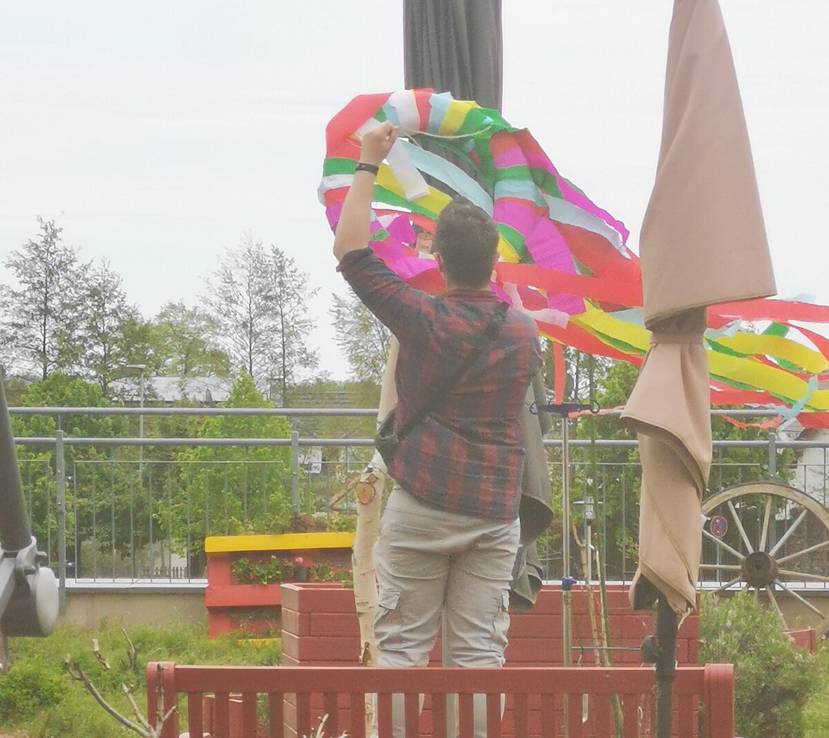Maibaum wir mit buntem Kranz geschmückt im Demenzgarten des Seniorenzentrum AGO Rosbach