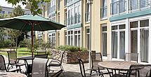 Auf der Terrasse des betreuten Wohnen im Pflegeheim Eisenhuettenstadt genießt man Kaffee und Kuchen.