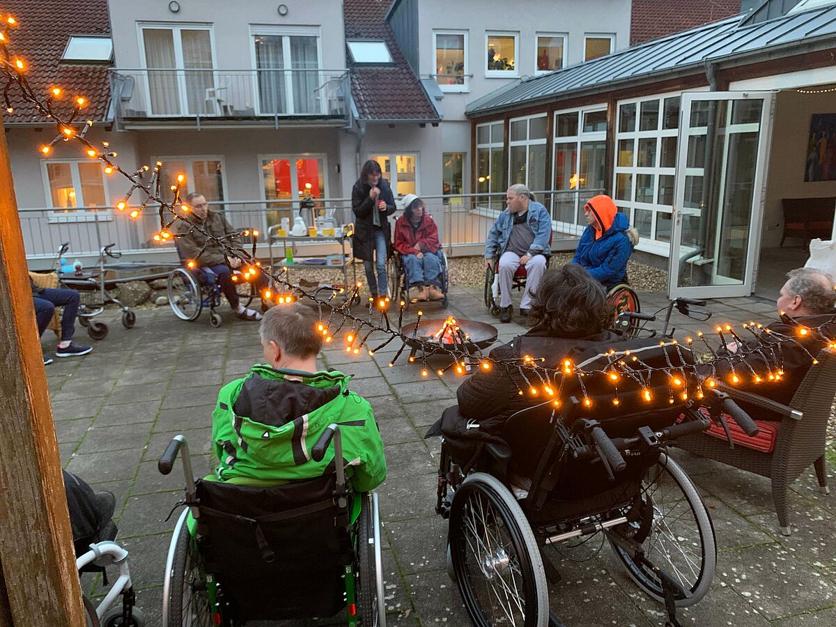 Bewohner sitzen an der Feuerschale