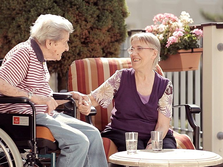 Auf der Sonnenterrasse im Pflegeheim genießen Sie schoene Stunden mit heiteren Gespraechen.