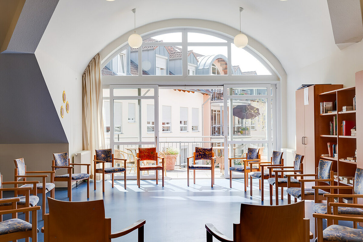 Stuhlkreis im Gemeinschaftsraum mit großem Fenster und viel Licht